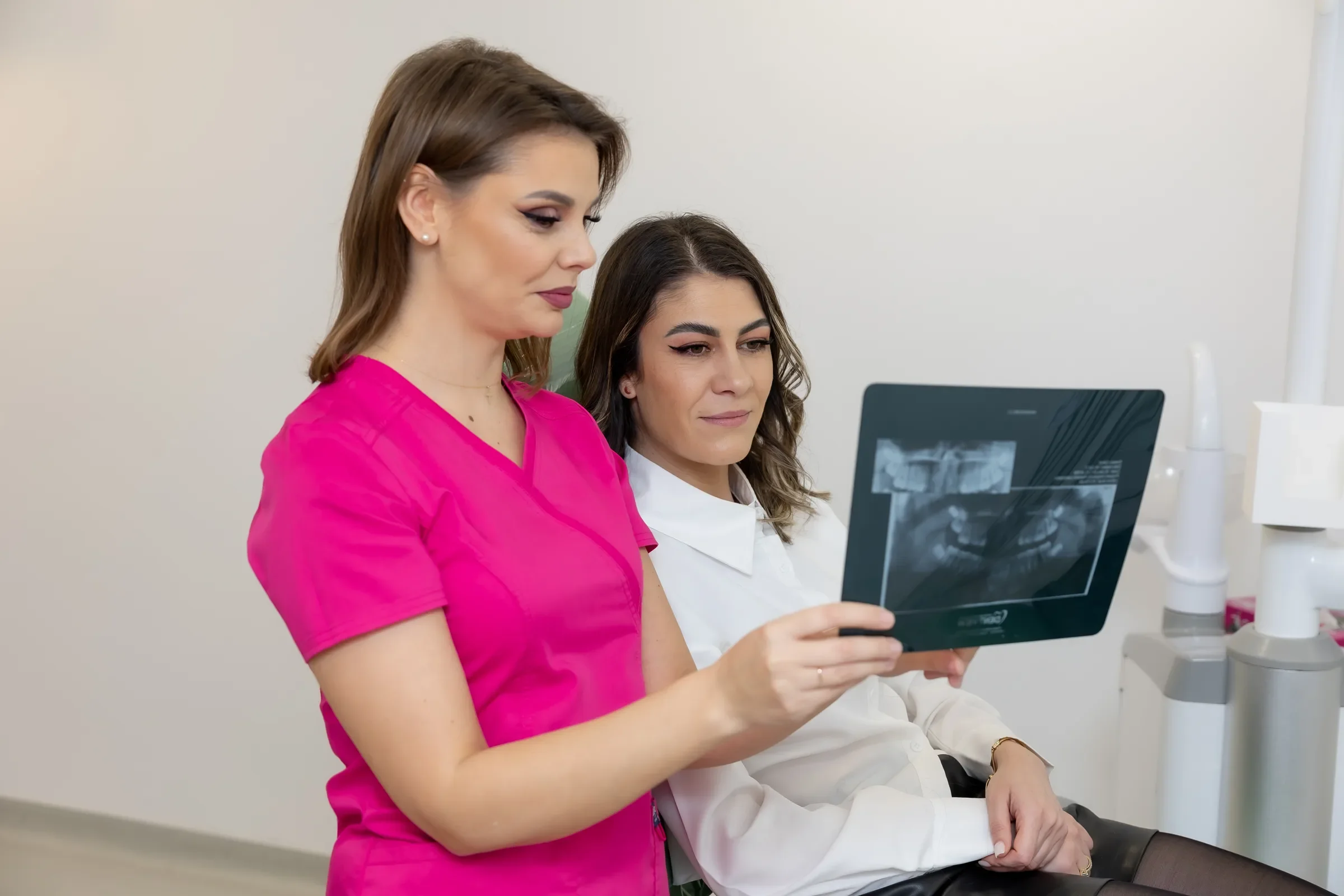 Medic SalvaDent care îi arată unei paciente o radiografie panoramică